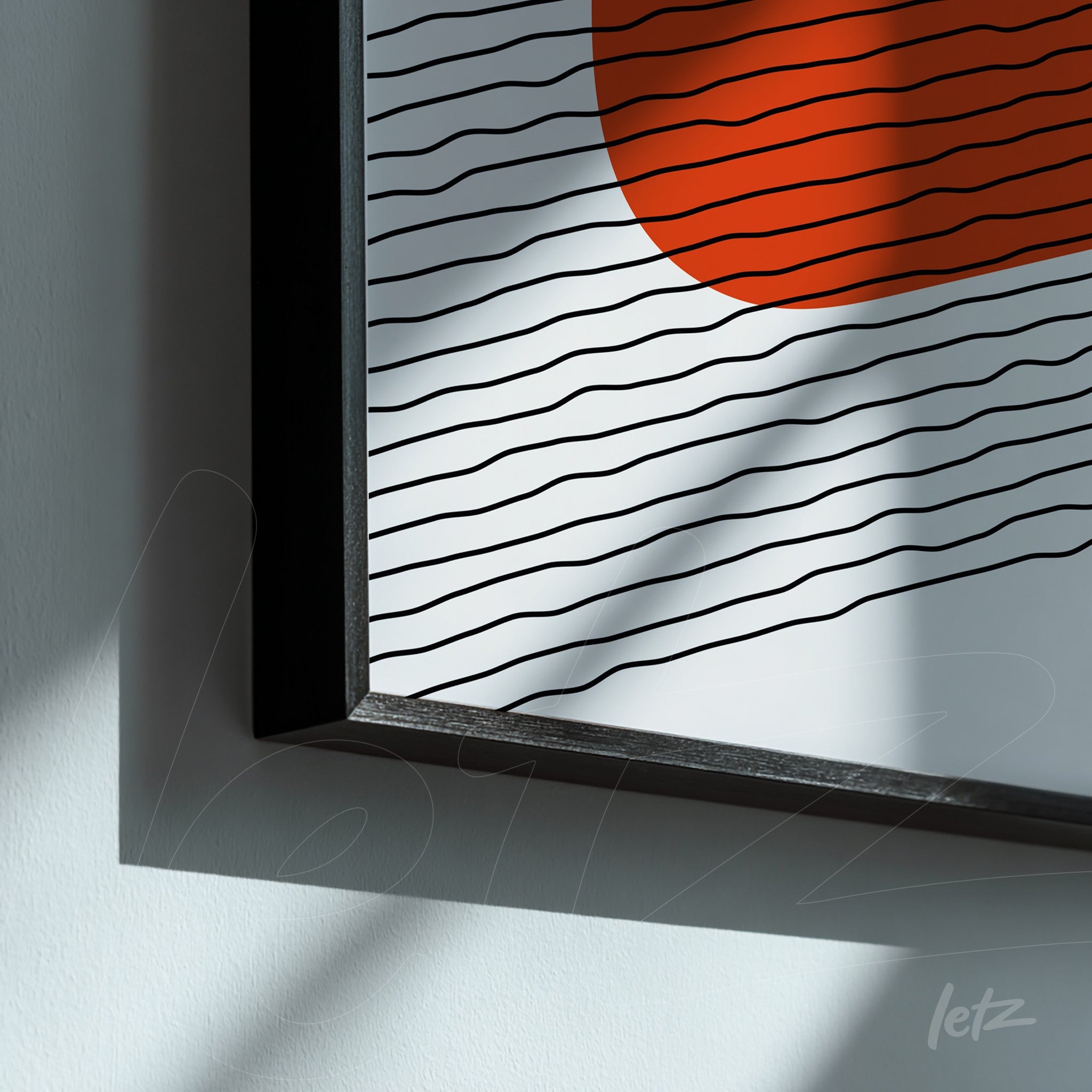 detalhe de quadro com formas abstratas em linhas pretas e um círculo laranja, moldura preta com iluminação suave