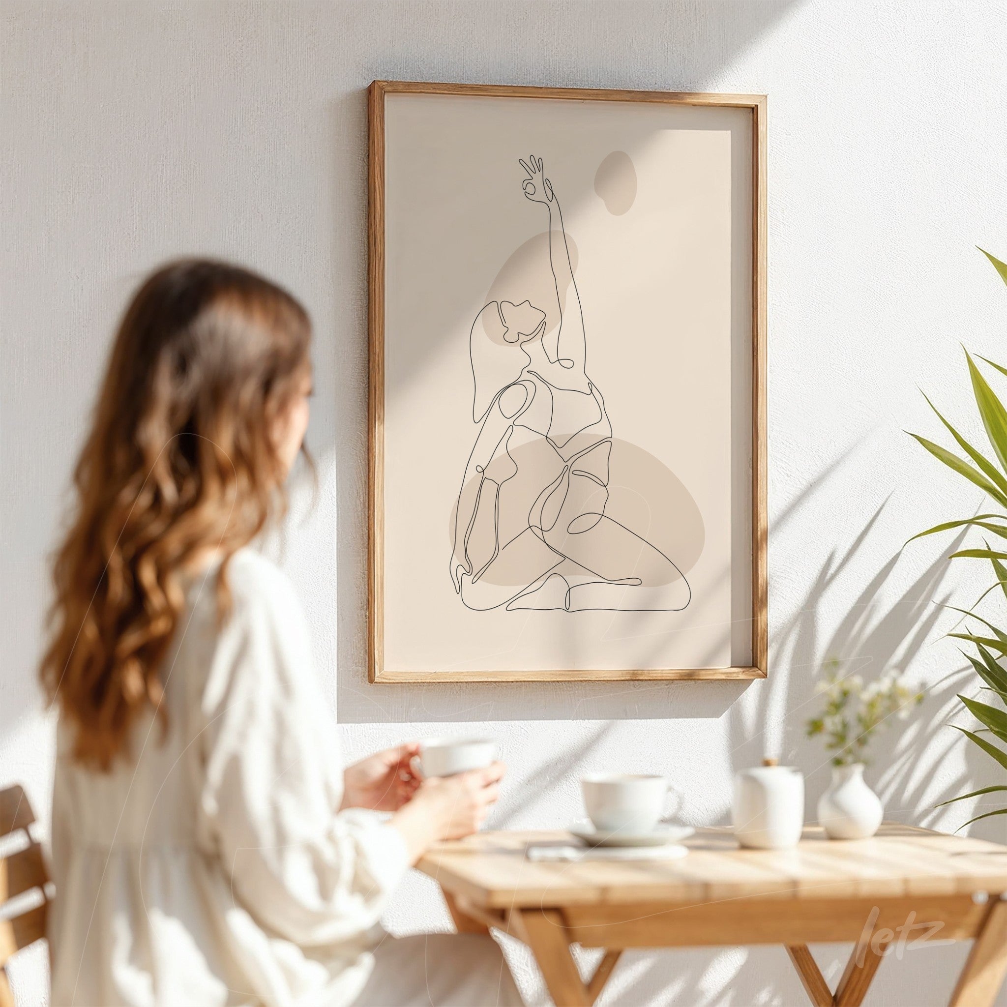 minimalist line art of a woman in a yoga pose, framed with light wood and displayed on a white wall