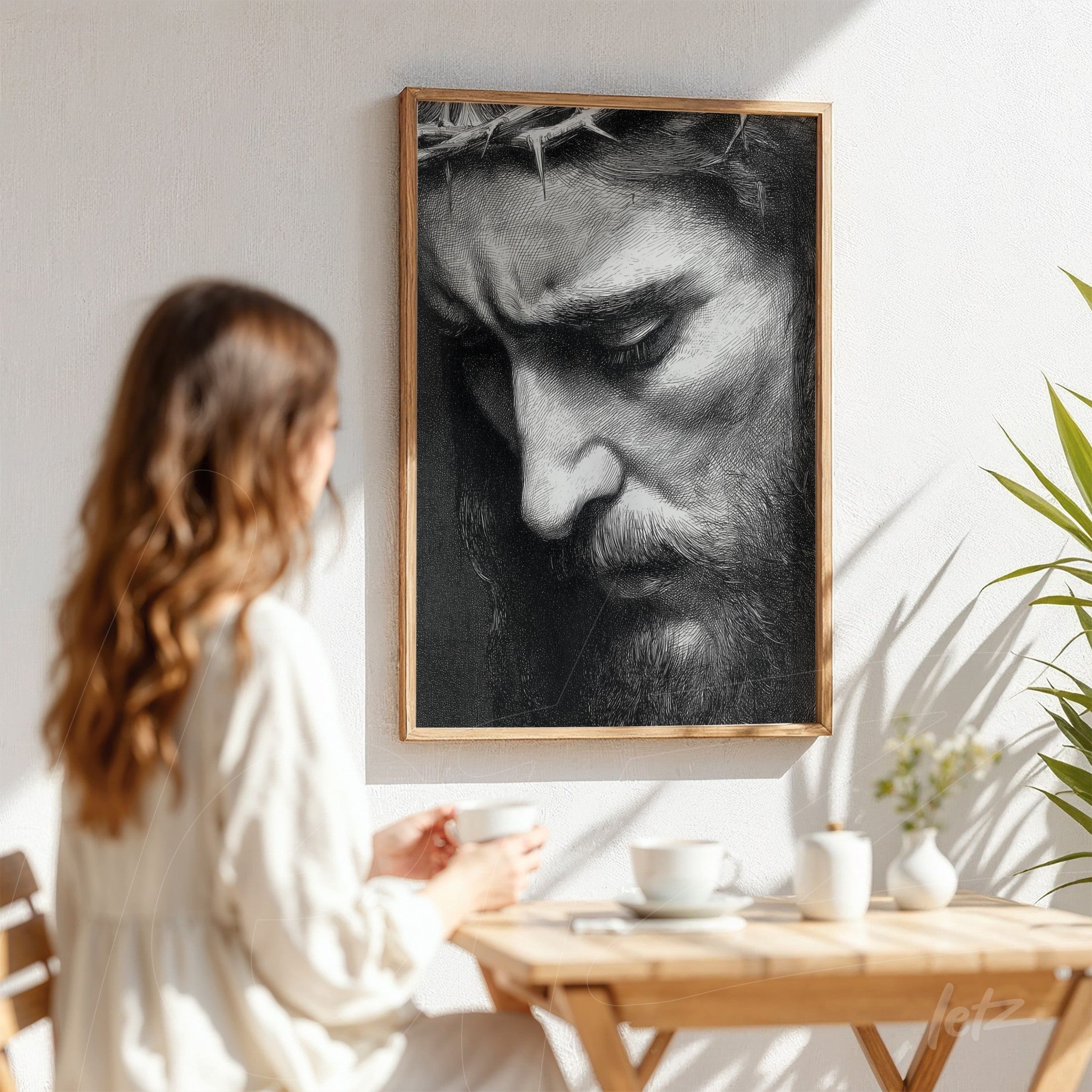 black and white framed wall art of Christ's portrait in a light wood frame displayed in a cozy setting