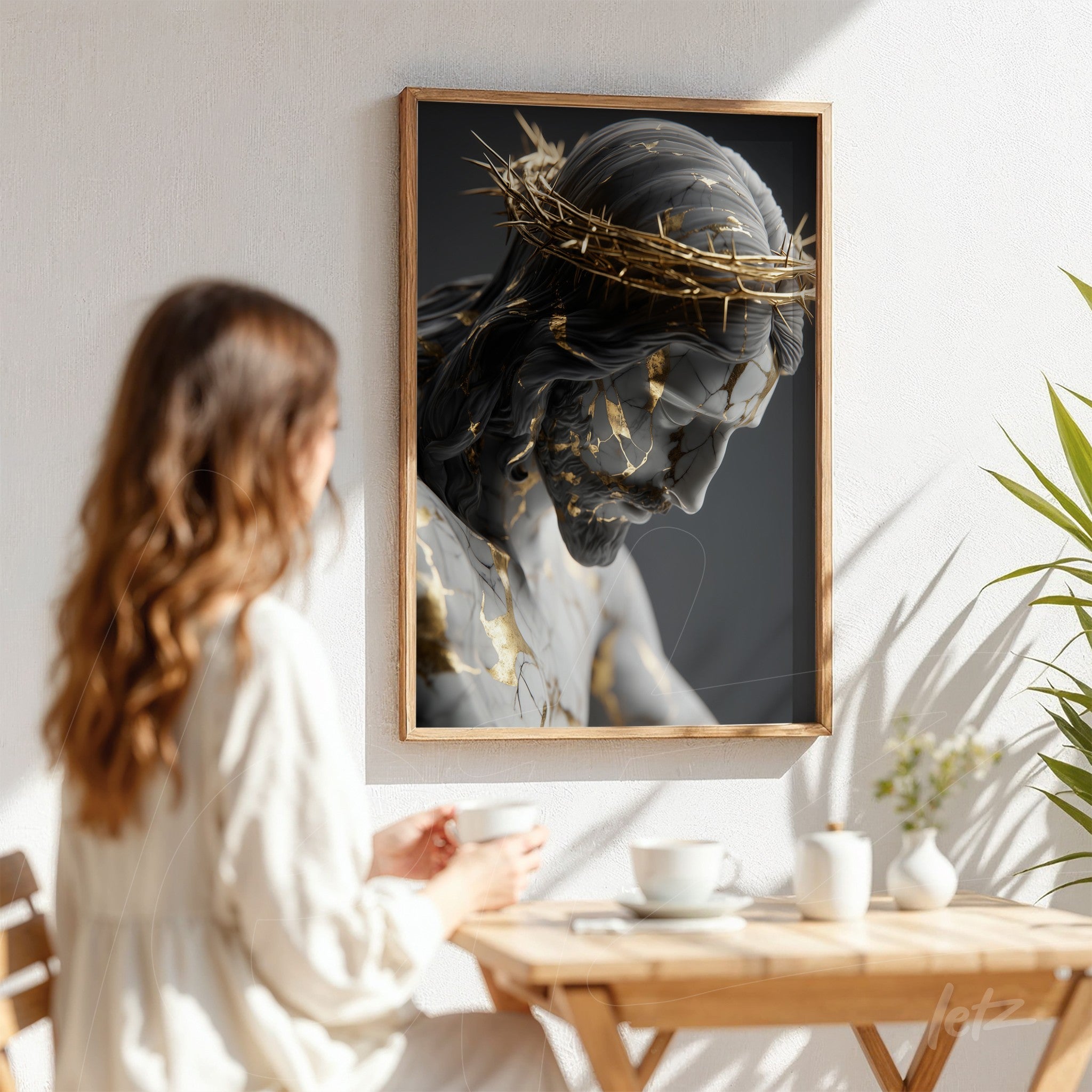 framed wall art featuring a detailed sculpture of Christ with golden accents displayed on a white wall next to a seated woman