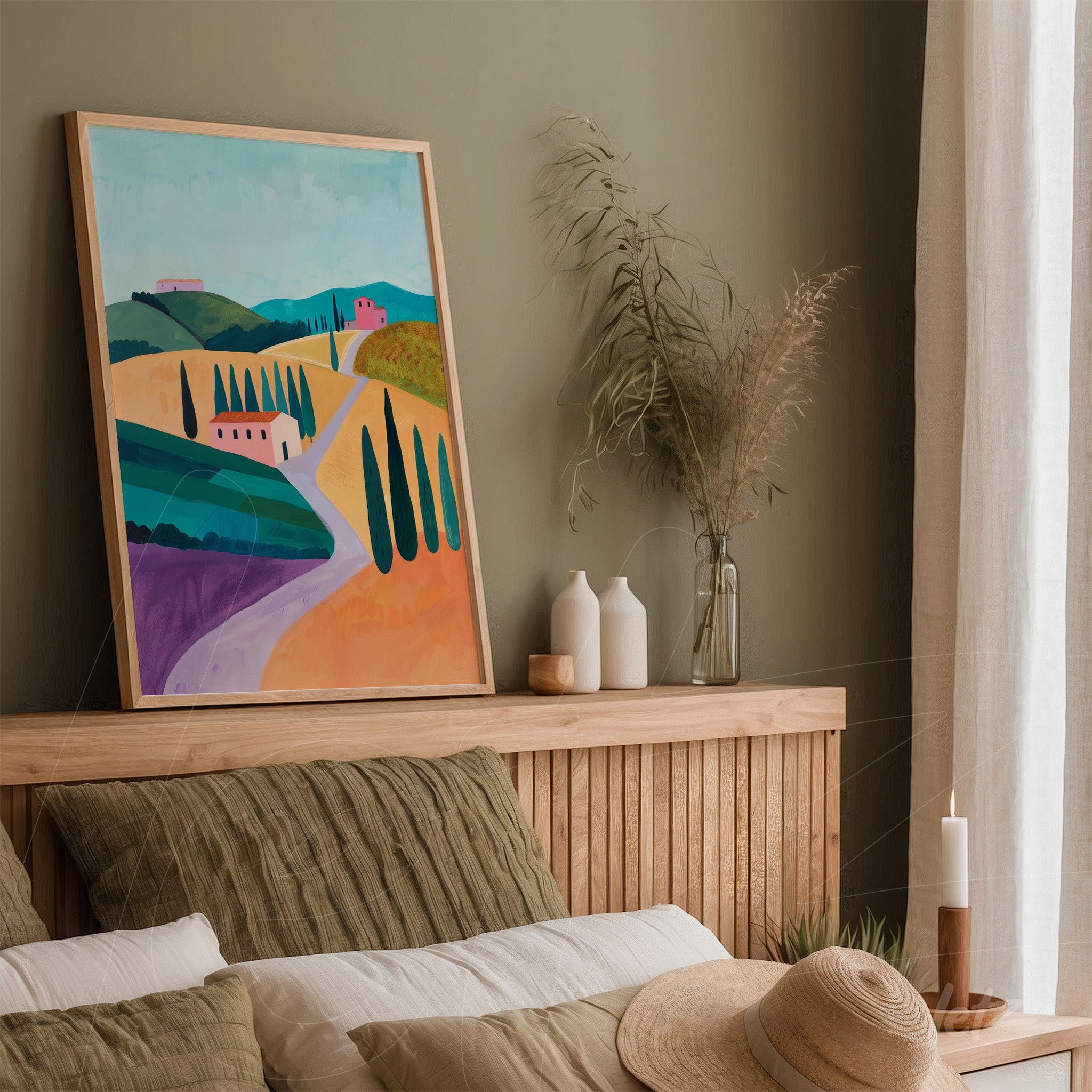 decorative artwork featuring a countryside landscape in a light wooden frame displayed on a bed headboard