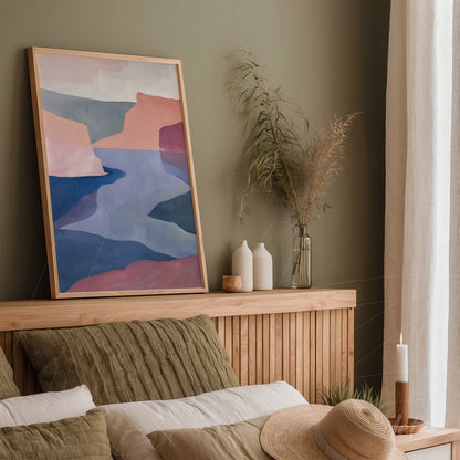 framed artwork featuring an abstract landscape in shades of pink and blue displayed on a wooden bed headboard in a cozy room