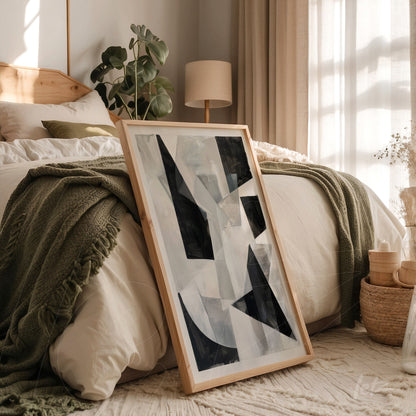 framed abstract art piece with light wood frame in a cozy bedroom setting