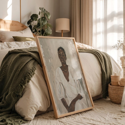 framed artwork in natural wood of seated woman portrait in a cozy bedroom setting