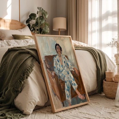 framed artwork featuring an expressive portrait of a woman sitting in a chair, wearing a light blue robe, leaning against the floor in a cozy bedroom