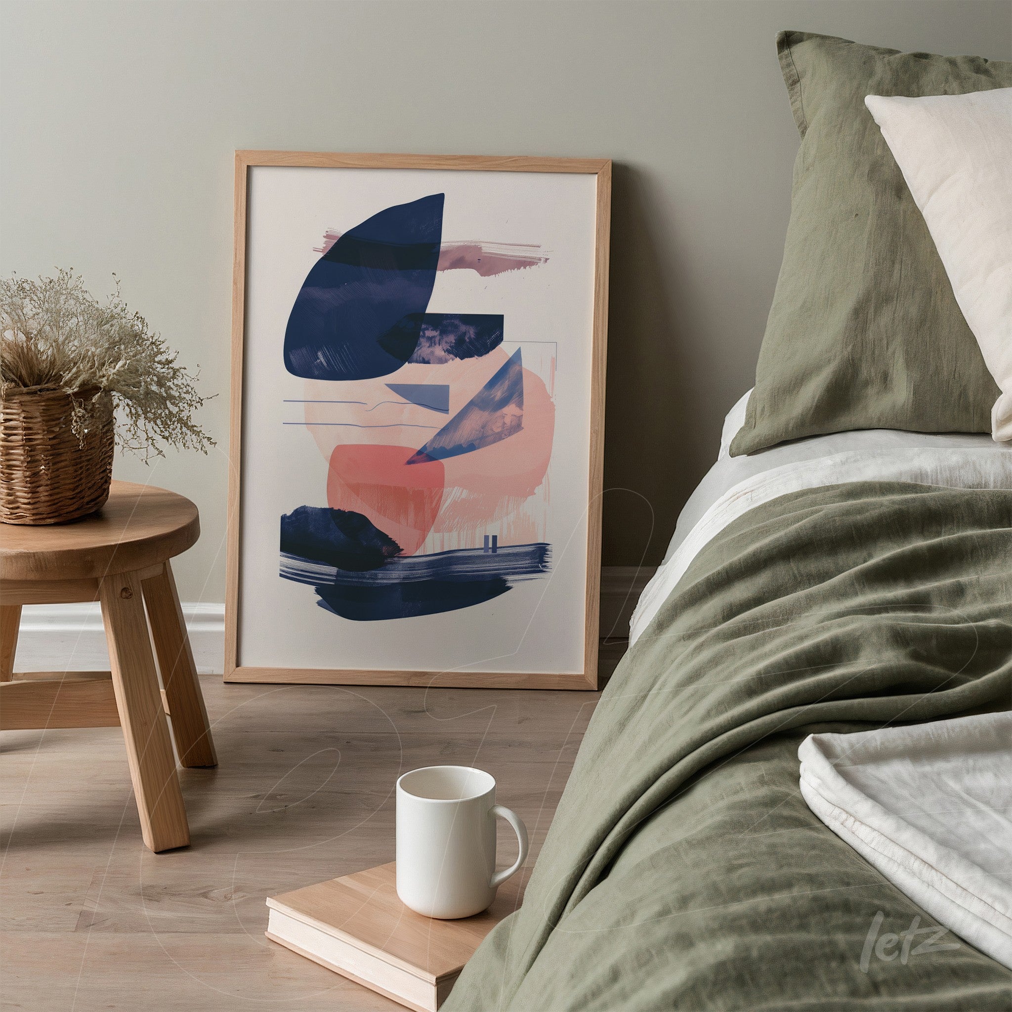 framed abstract wall art with light wood frame displayed next to a bed featuring neutral bedding, vase with dried flowers on wooden side table
