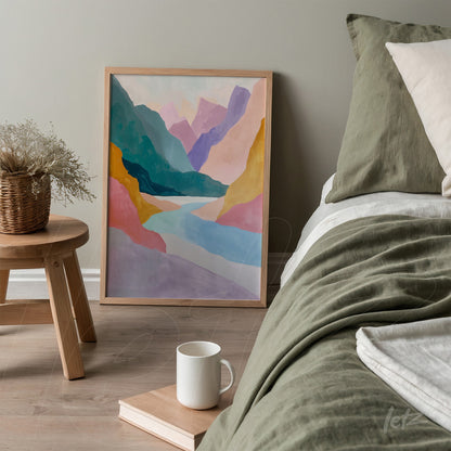 framed abstract landscape art in pastel colors displayed next to a bed in a minimalist setting