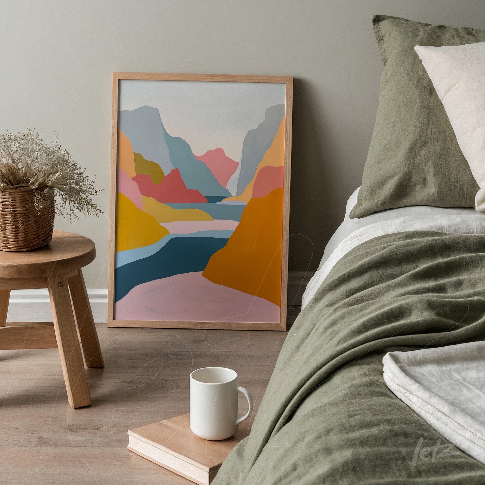 framed wall art featuring abstract landscape in soft shades of blue, pink, yellow, and gray displayed against a light gray wall next to a bed with green linens
