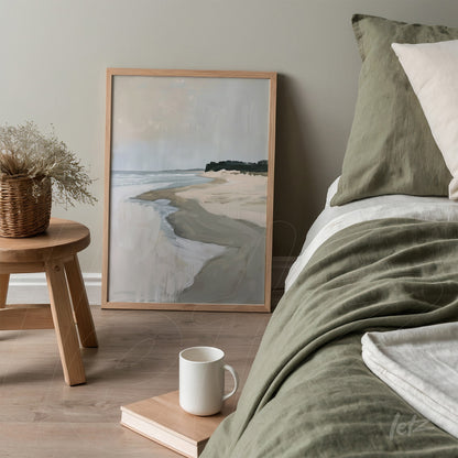 framed abstract art featuring a beach landscape with sea in the background, leaning beside a bed with green bedding