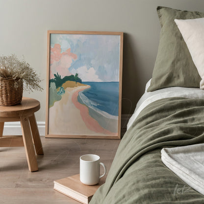 framed abstract beach landscape art in light wood, leaning beside a bed with green bedding