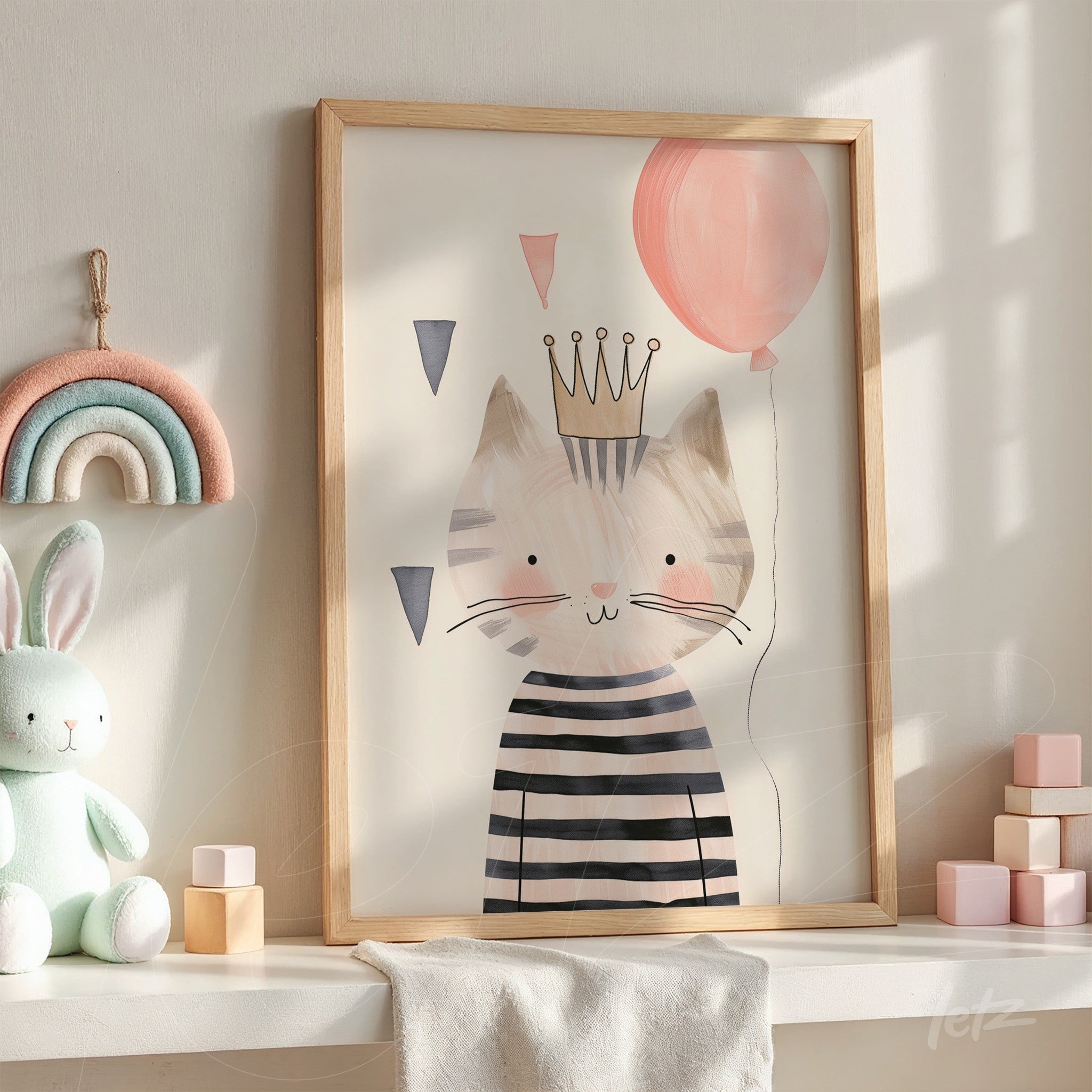 framed artwork of a cat wearing a crown and striped shirt in light wood frame