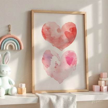 framed wall art featuring watercolor illustrations of pink and red hearts in light wood frame displayed on a shelf next to children's toys