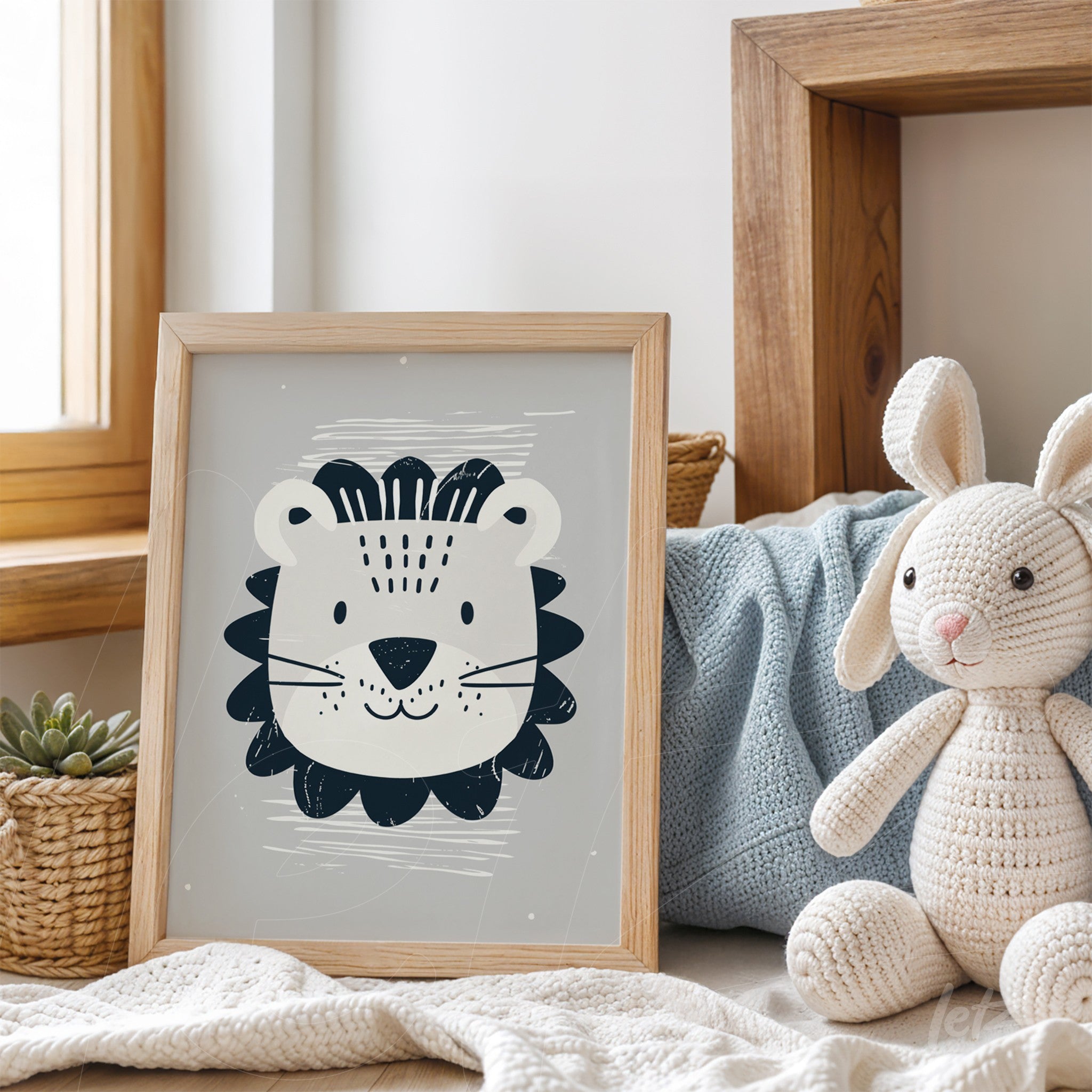 framed artwork featuring a stylized lion illustration on gray background with light wood frame displayed on a table next to a plush bunny