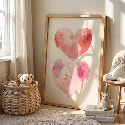 framed watercolor art of hearts in shades of pink and red with light wood frame leaning beside a wicker basket