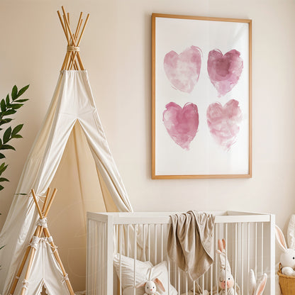 framed wall art featuring four watercolor hearts in shades of pink with a light wooden frame