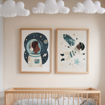 framed artwork composition featuring astronaut illustrations with light wood frames displayed above a crib in a children's room