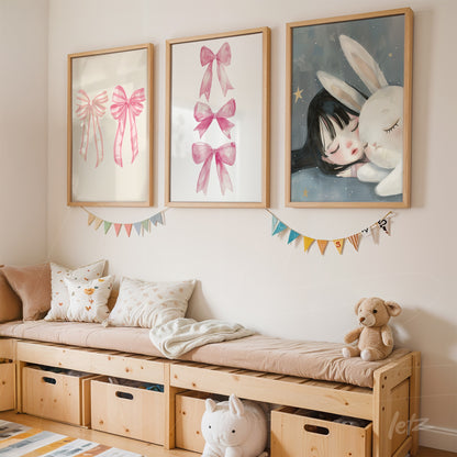 framed artwork composition with soft illustrations including pink bows and a girl with a bunny, arranged above a light wood bench in a children's room