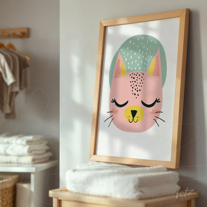 framed artwork of a stylized cat with a light wood frame displayed in a setting with stacked towels