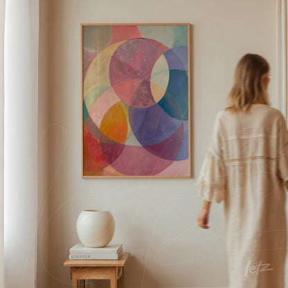 abstract art piece with pink, blue, and purple circles in a light wood frame