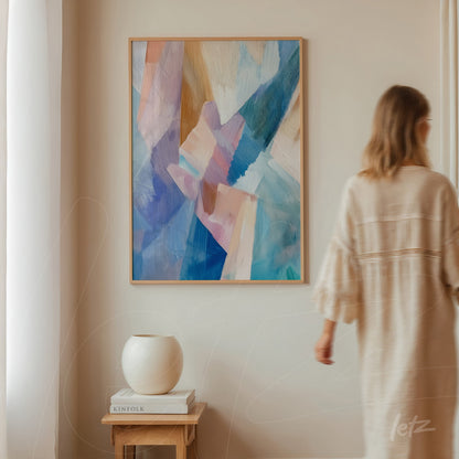 abstract artwork with brushstrokes in shades of blue and pink in a light frame displayed on a neutral wall