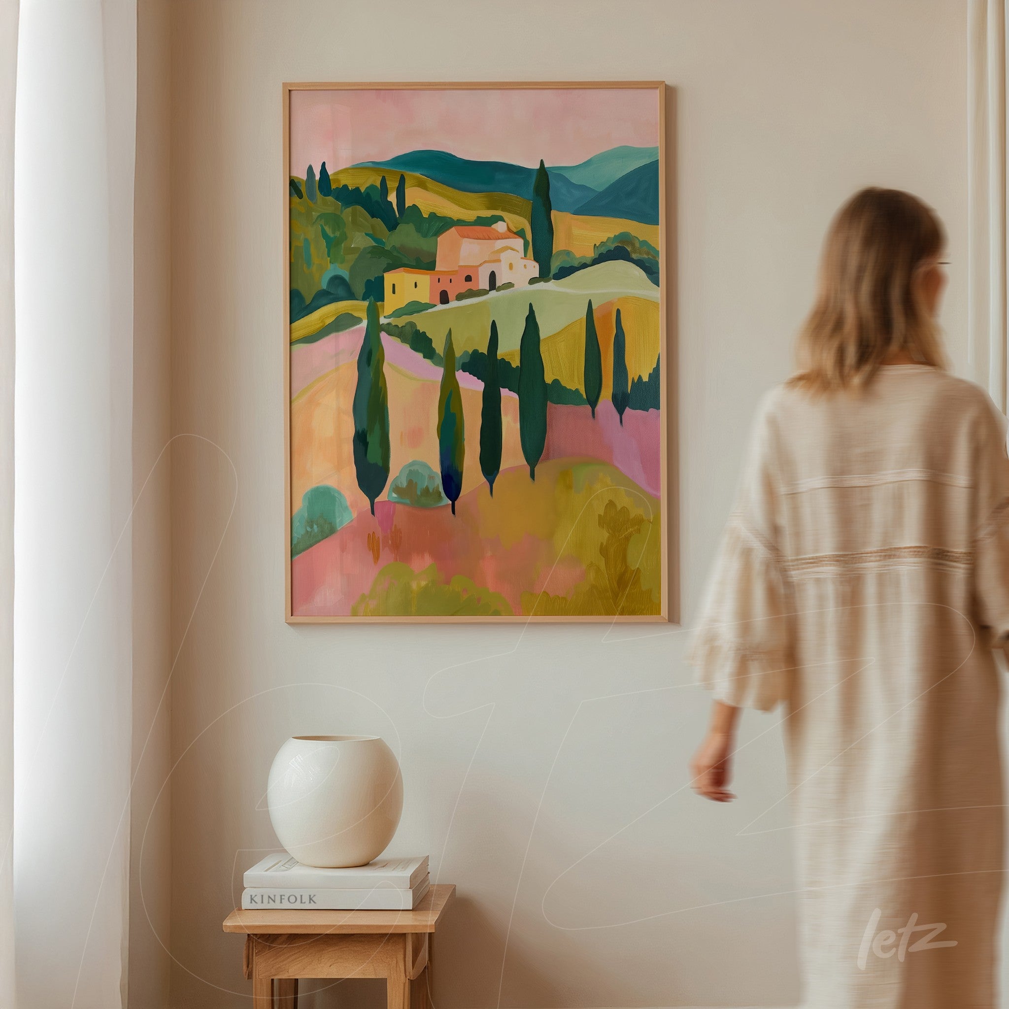 framed artwork of vibrant rolling hills and cypress trees in light frame displayed on a neutral wall with decorative vase nearby