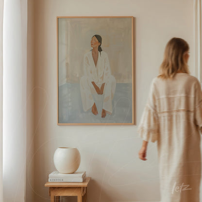 framed wall art featuring a minimalist portrait of a woman in white clothing against a light wall