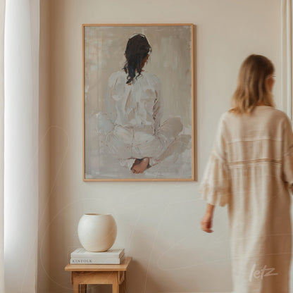 contemporary wall art depicting a seated female figure from behind in a light frame on a neutral wall