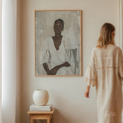 framed portrait of a dark-skinned woman in white attire with a light frame