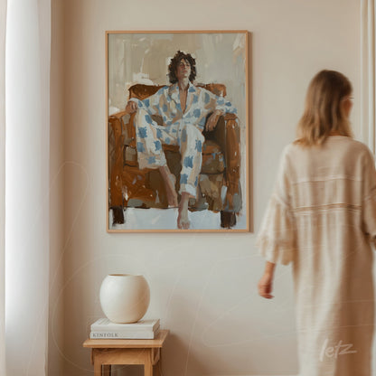 framed artwork depicting a seated figure in floral patterned loungewear on a brown sofa