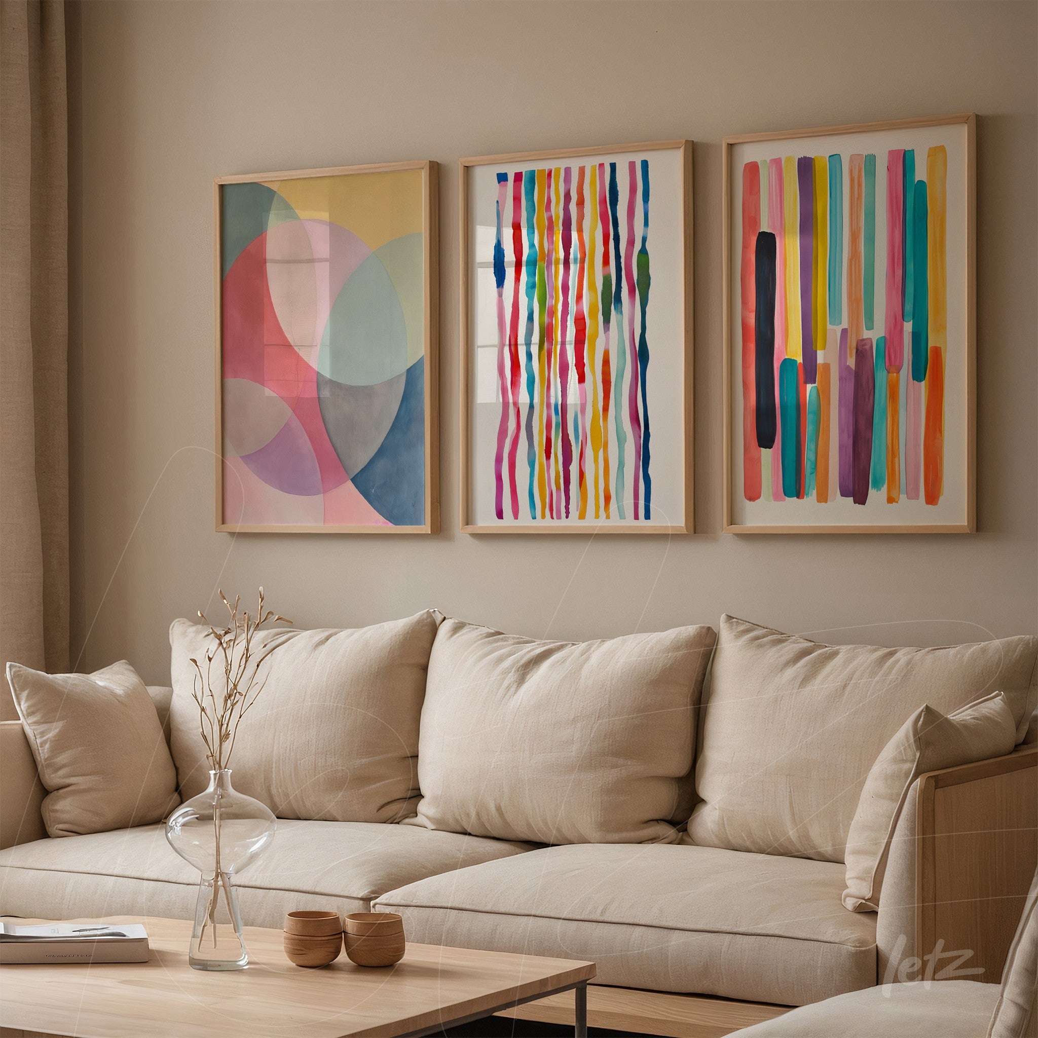composition with three decorative wall art pieces featuring colorful stripes and geometric shapes mounted on light wall, displayed in light wood frames