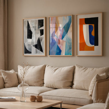 three framed artworks displayed above a beige fabric sofa featuring abstract compositions in black, blue, and orange