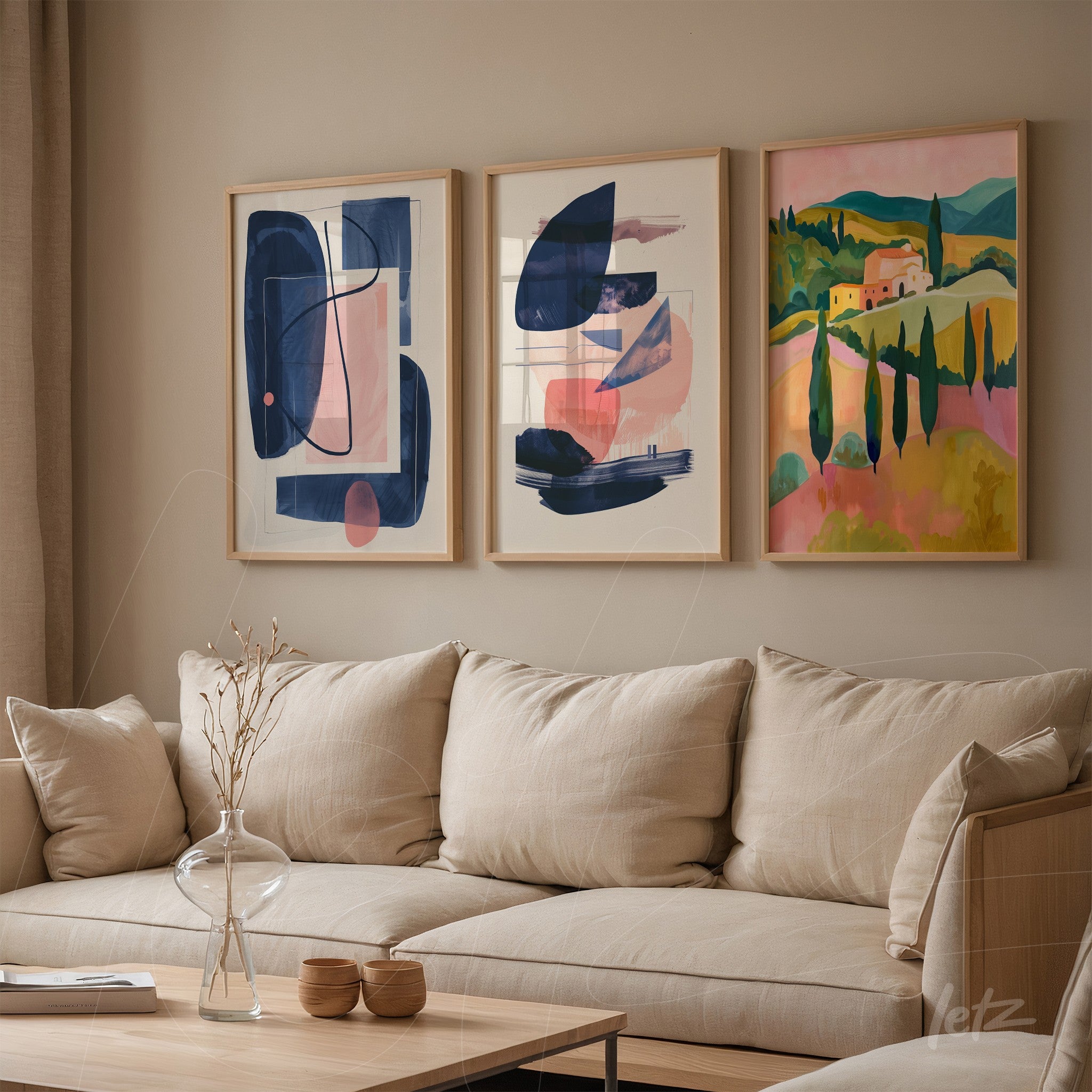 composition of three abstract framed artworks with light wood frames displayed on a neutral wall beside a beige fabric sofa