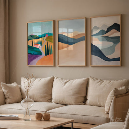 set of three framed artworks featuring colorful landscapes in light wood frames displayed on beige wall beside a neutral fabric sofa