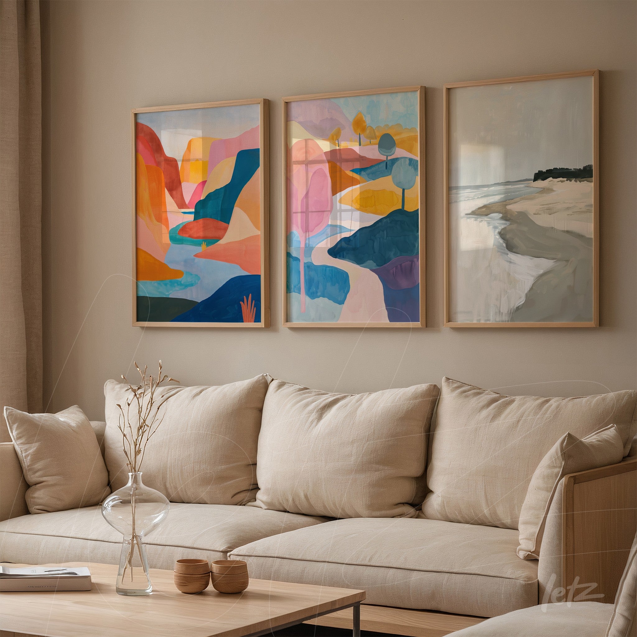 composition of three framed artworks featuring abstract landscapes in vibrant shades of blue, orange, and pink displayed on a neutral wall next to a light fabric sofa