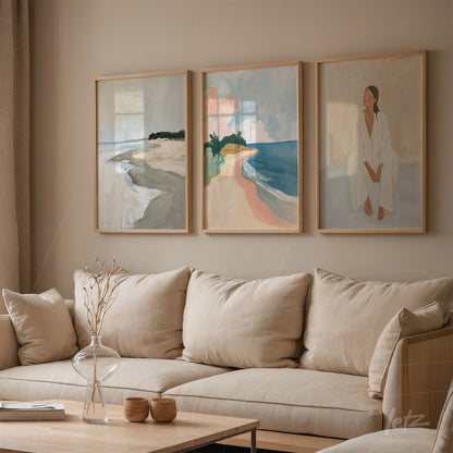 set of three framed contemporary artworks in light wood frames depicting beach landscapes and a seated female figure in soft colors