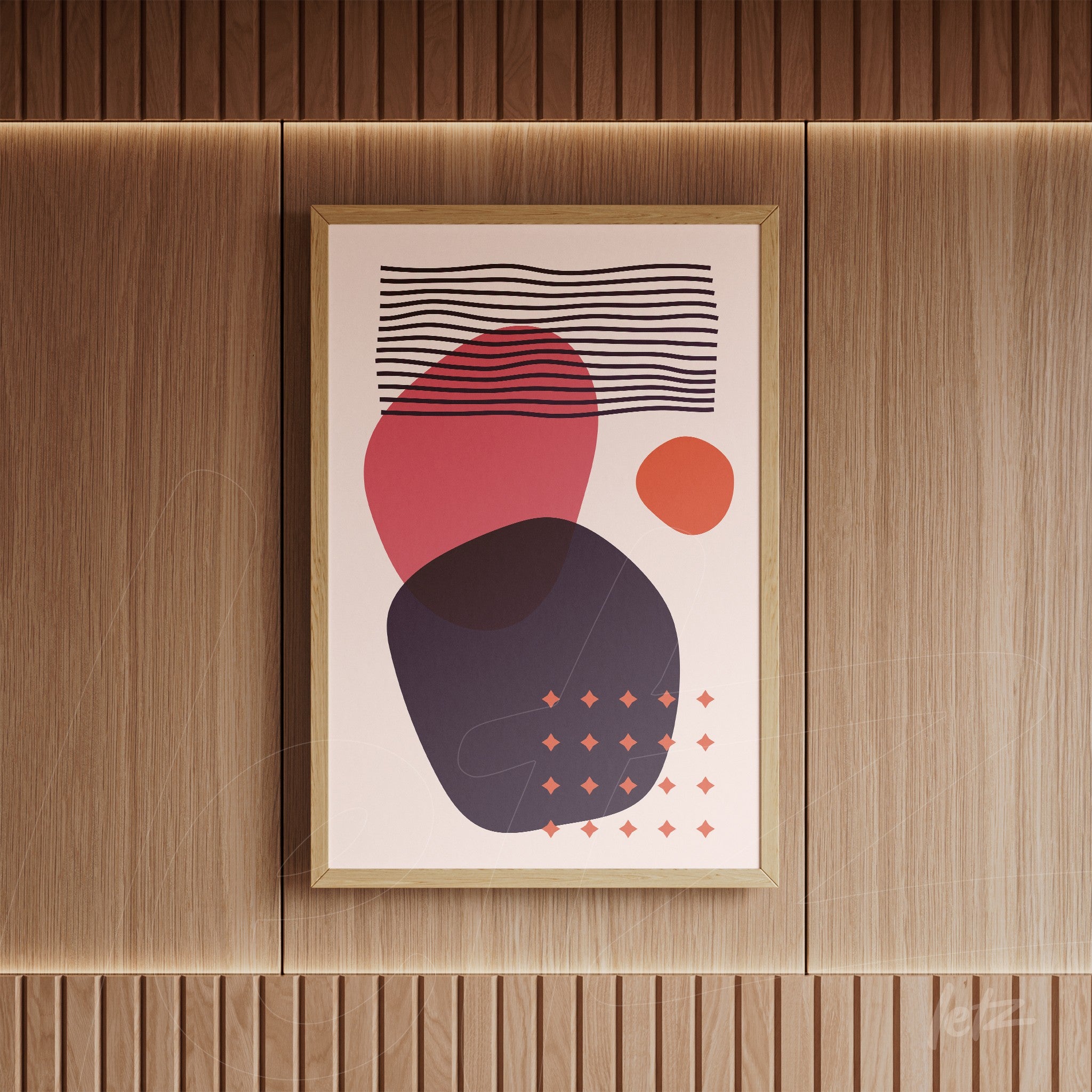 poster featuring geometric shapes in red and dark blue with a gold frame on a wooden wall