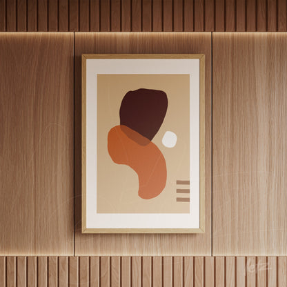 abstract art in light wood frame with organic shapes in earthy tones on wood-paneled wall