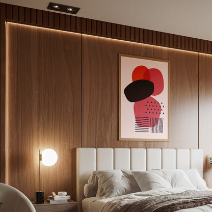 abstract art in red and black tones on a pink background with light wood frame displayed in a modern bedroom