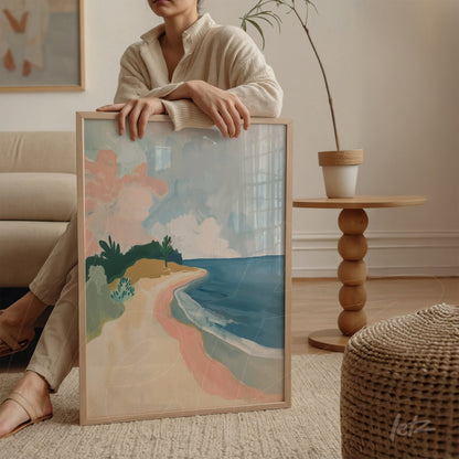 framed artwork in light wood depicting an abstract beach scene with soft colors of sand, sea, and greenery