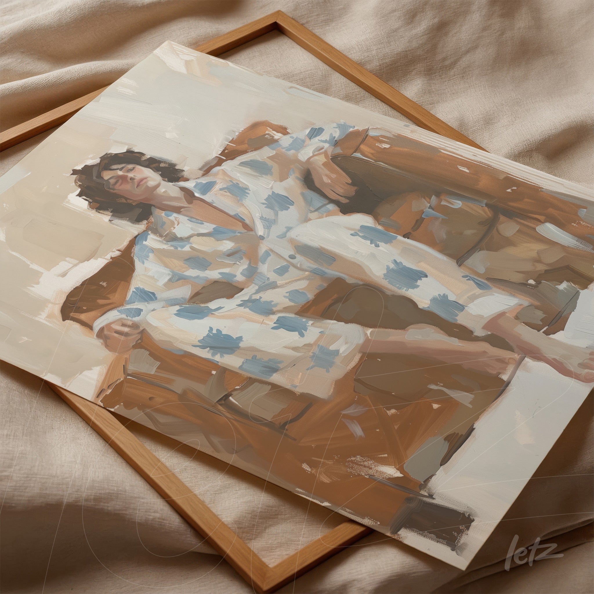 framed artwork of a woman relaxing on a couch in a blue and white patterned pajama with a light wooden frame