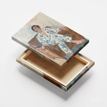 canvas artwork of a figure sitting on a couch wearing blue patterned pajamas on a wooden base