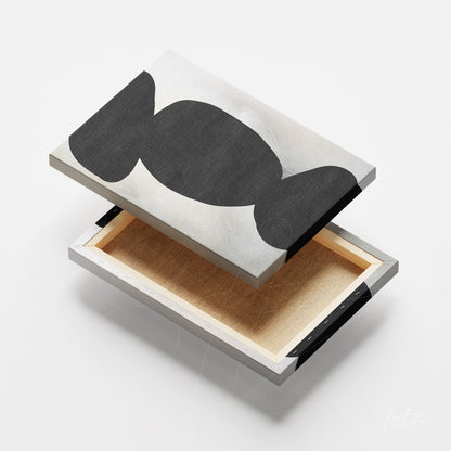 detail of canvas artwork featuring abstract black and white design with exposed metal frame