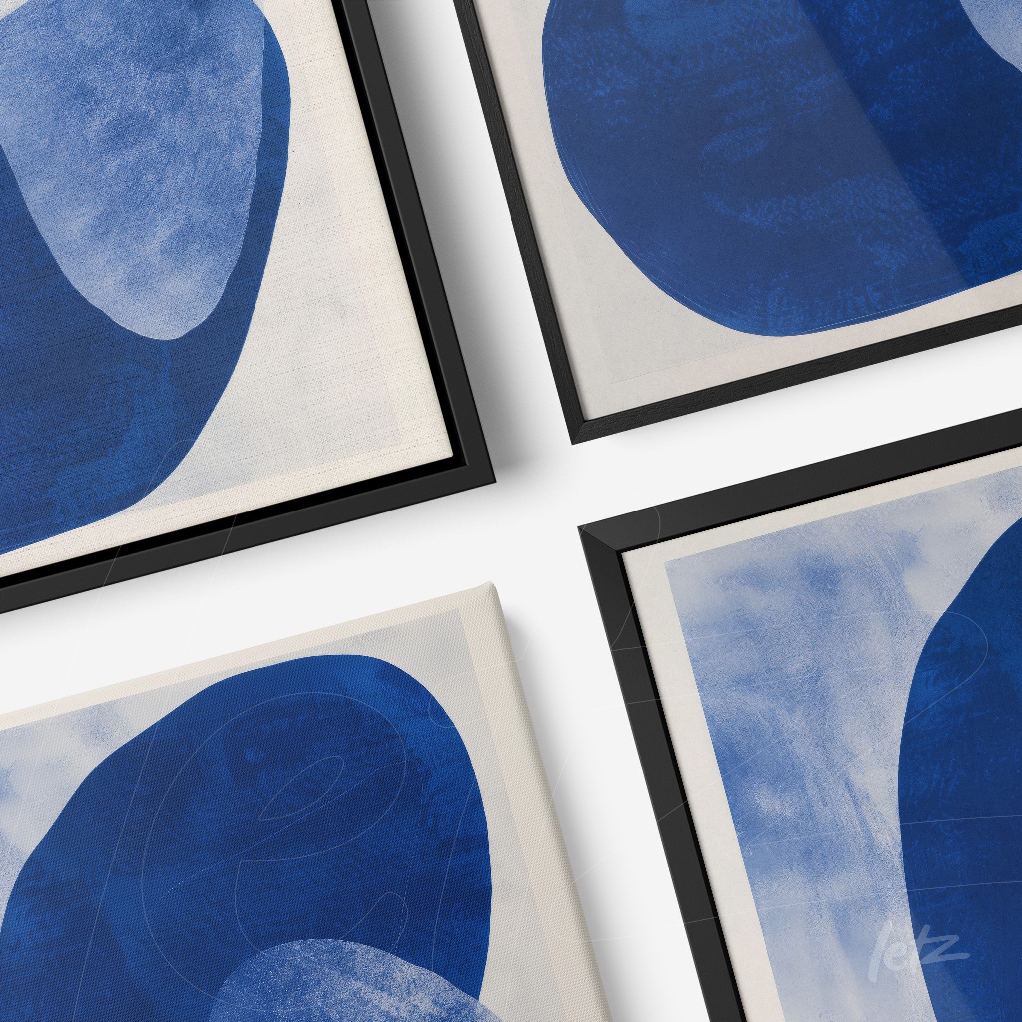 composition of framed abstract wall art in blue with elegant black frames and light background