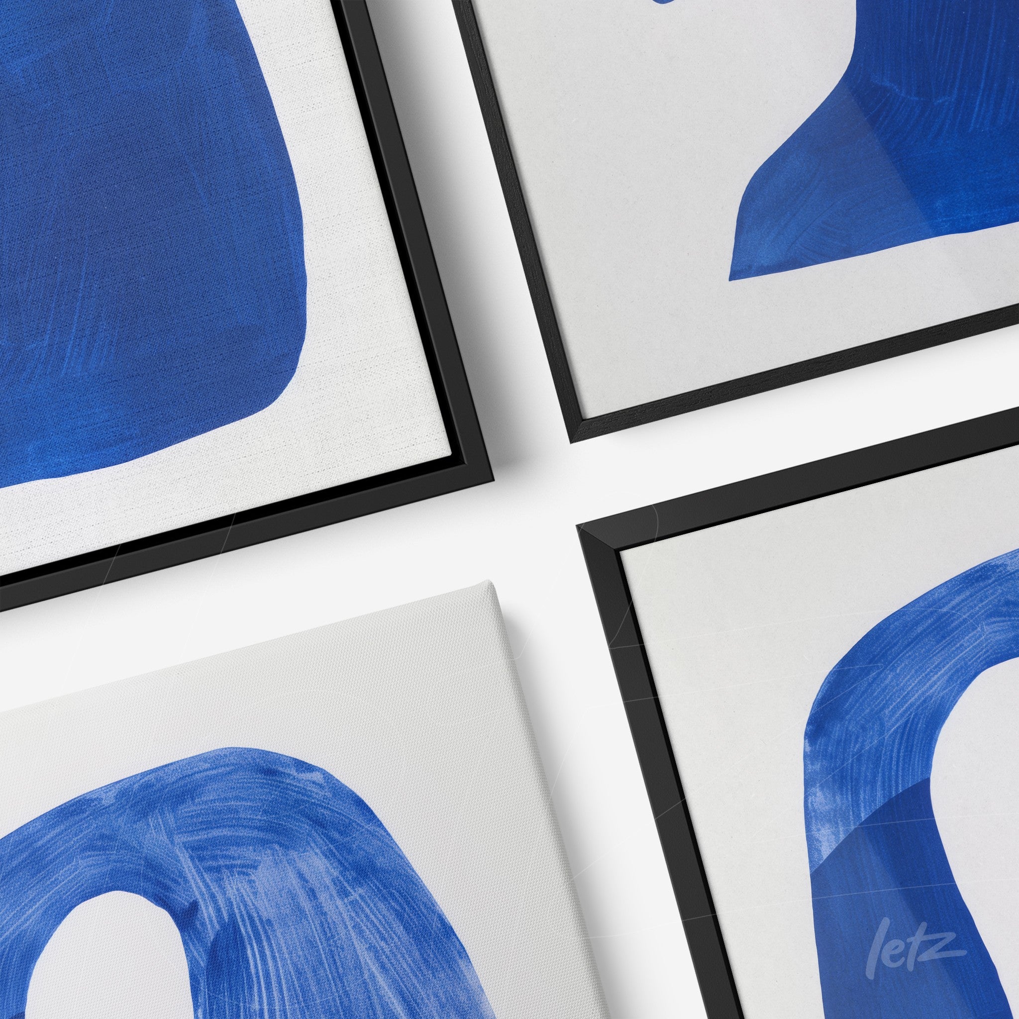 collection of modern wall art featuring abstract blue shapes in black frames