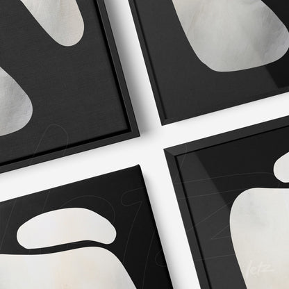 series of abstract wall art in black and white tones with sleek black frames