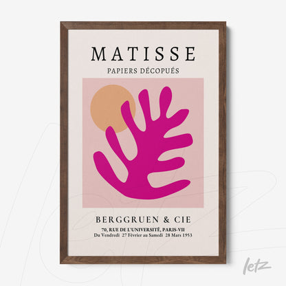 framed modern art print featuring colorful cutouts in pink and orange with a dark wood frame