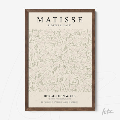 framed wall art featuring floral design on a light background with various green elements and dark wood frame