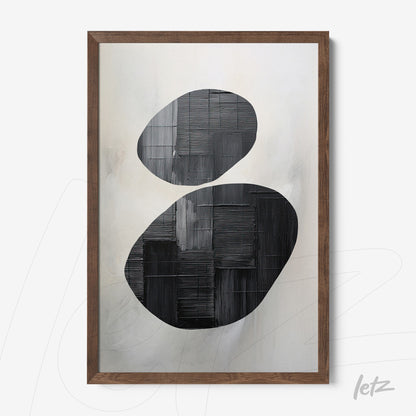 abstract wall art in black and white featuring oval forms in relief on a soft background with dark wooden frame