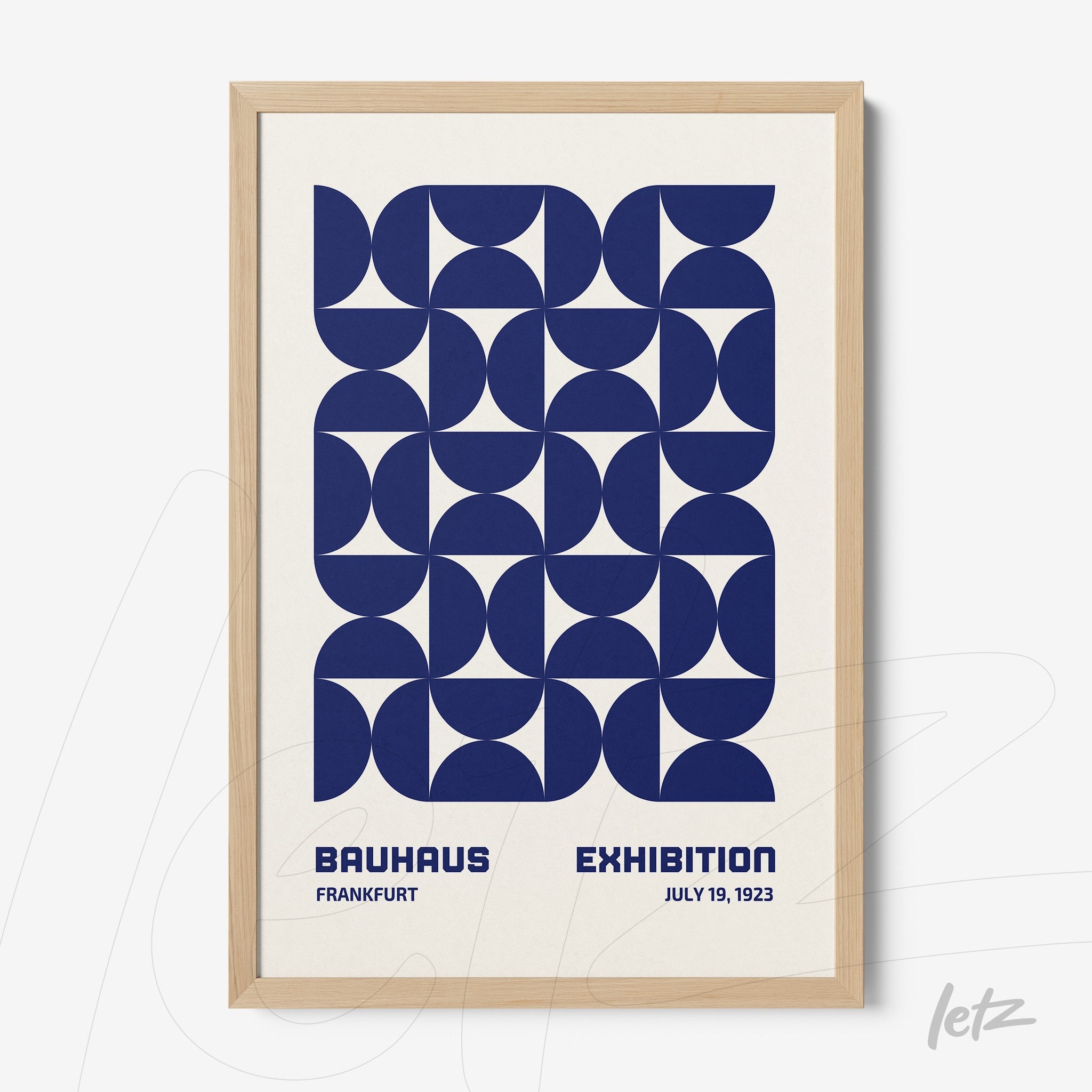 framed wall art with navy blue geometric design in Bauhaus style, set in a light wood frame