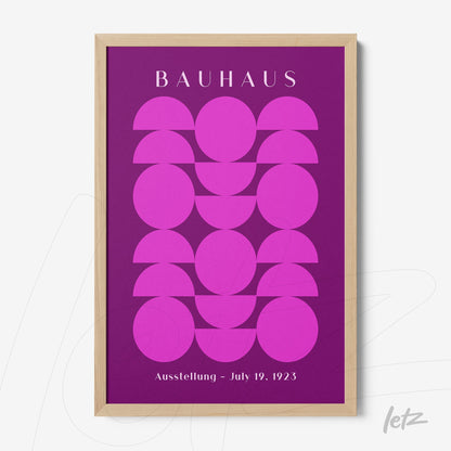 poster featuring geometric art in pink shades on a purple background, framed in light wood